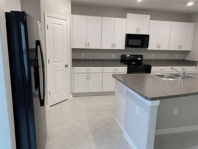 a kitchen with stainless steel appliances granite countertop a refrigerator stove and sink