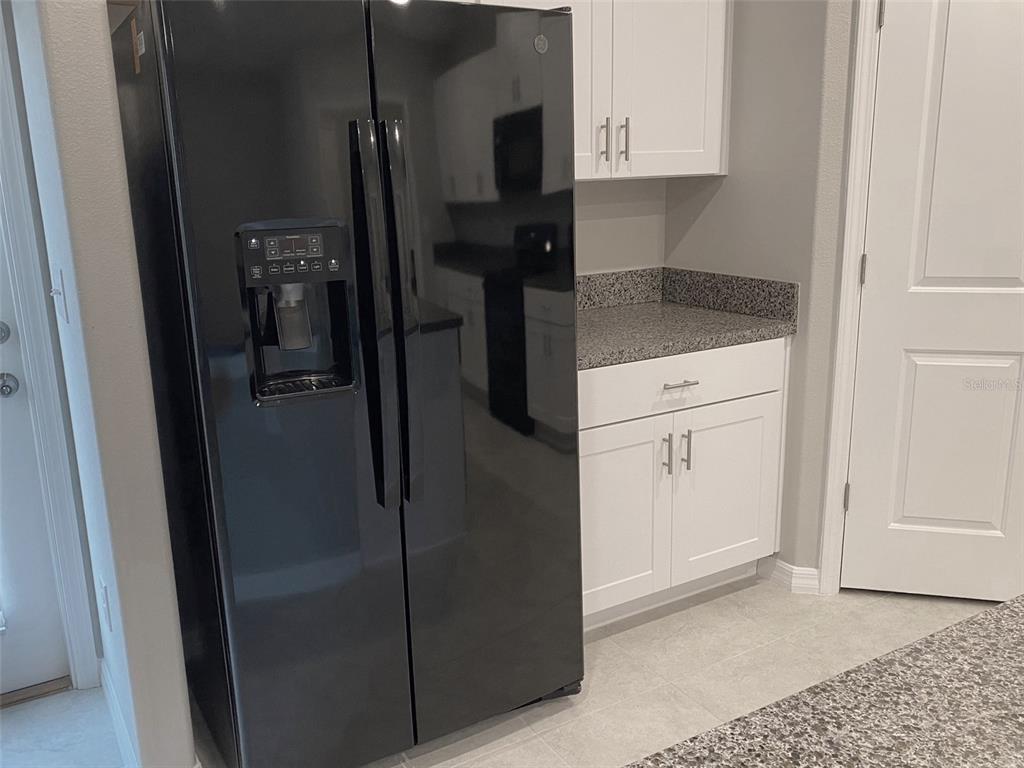 3816 Hanover Drive New Port Richey, FL 34653 - Photo 9 of 64 a kitchen with a refrigerator and cabinets