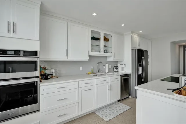 a kitchen with stainless steel appliances granite countertop a stove a sink and a refrigerator