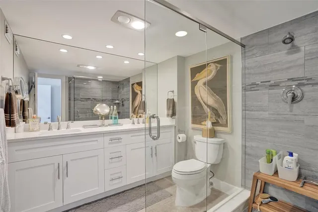 a bathroom with a toilet sink double vanity and mirror