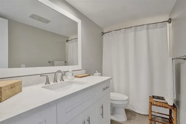 a bathroom with a sink a toilet and a mirror