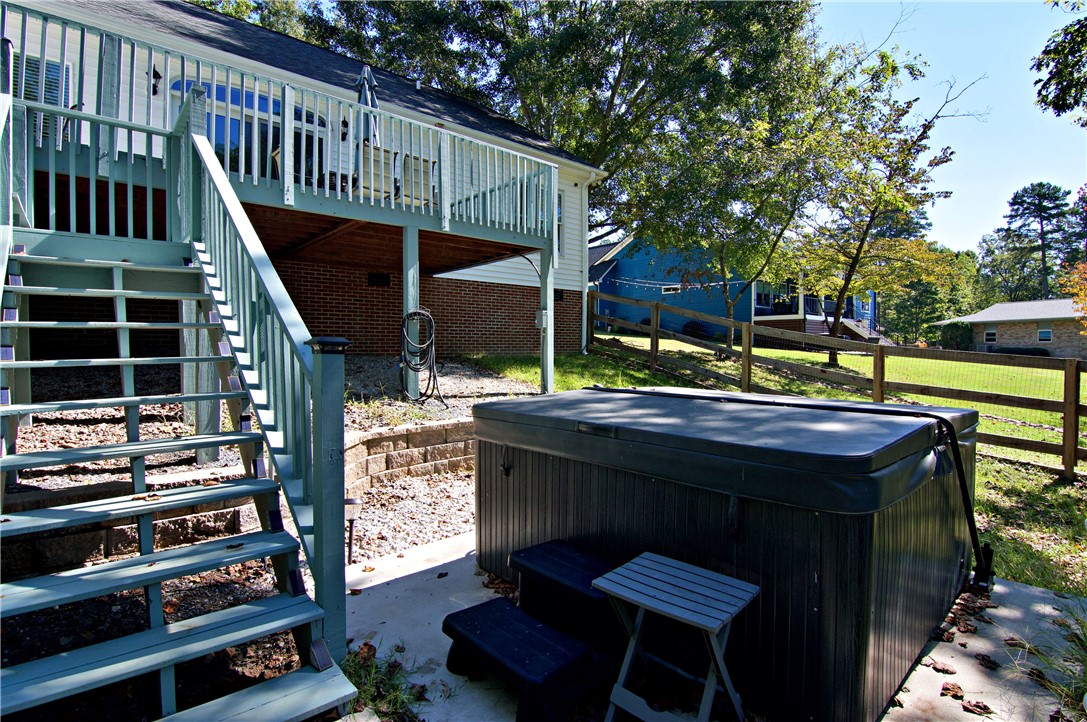 206 Petty Road Seneca, SC 29672 - Photo 32 of 49 An elevated wood deck overlooks a shaded concrete patio featuring a private hot tub.