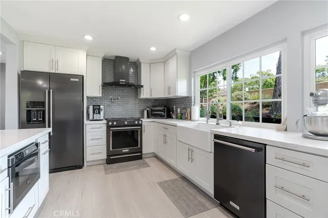 a kitchen with stainless steel appliances granite countertop a stove a sink and a refrigerator
