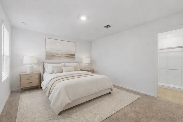 a bedroom with a bed and a night stand