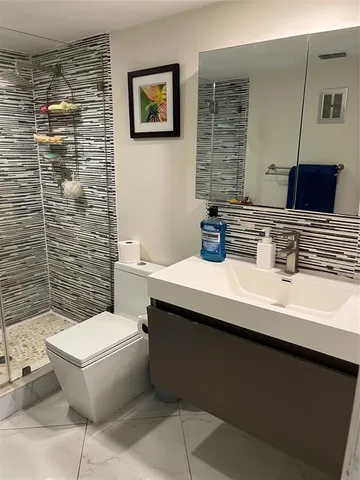 a bathroom with a toilet a sink and mirror