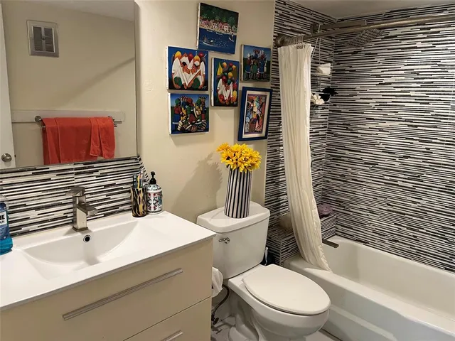 a bathroom with a sink a toilet and shower curtain