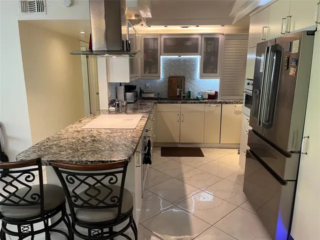 a kitchen with stainless steel appliances granite countertop a refrigerator and a stove