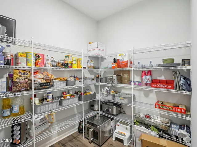 a storage room with washer and lots of wooden floor