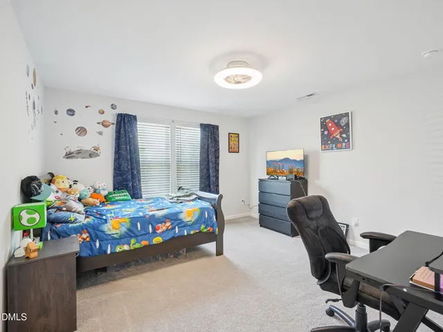 a bedroom with a bed table and a window