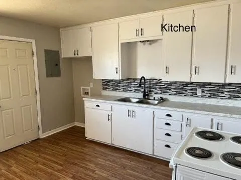a kitchen with granite countertop a white stove and cabinets