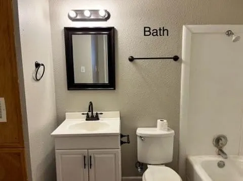 a bathroom with a toilet sink and mirror