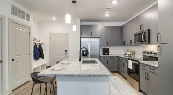 a kitchen with stainless steel appliances granite countertop a sink refrigerator and cabinets