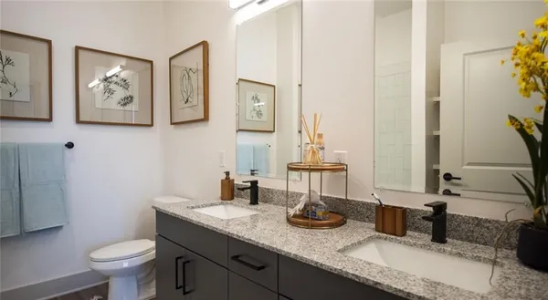 a bathroom with a granite countertop sink and a toilet