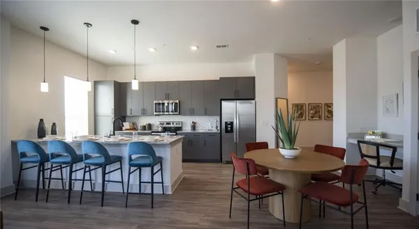 a kitchen with a dining table chairs and refrigerator