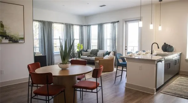 a kitchen with a dining table chairs and large windows