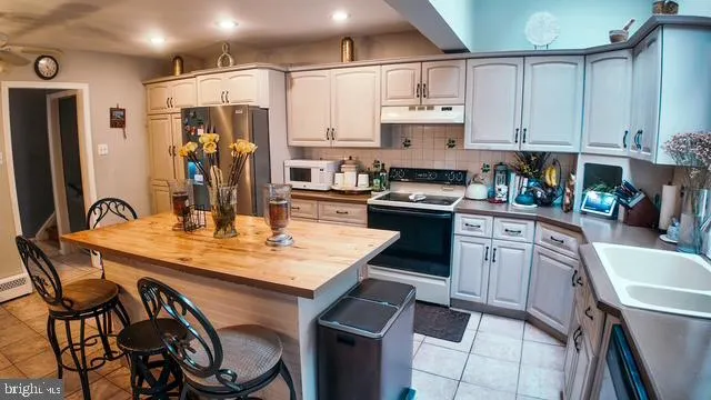 a kitchen with stainless steel appliances granite countertop a sink a stove a refrigerator and cabinets