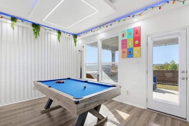 a room with furniture pool table and wooden floor