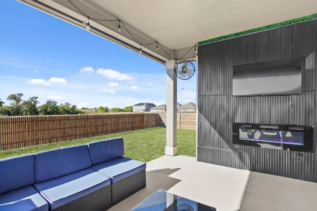 a view of a roof deck with couches and wooden floor