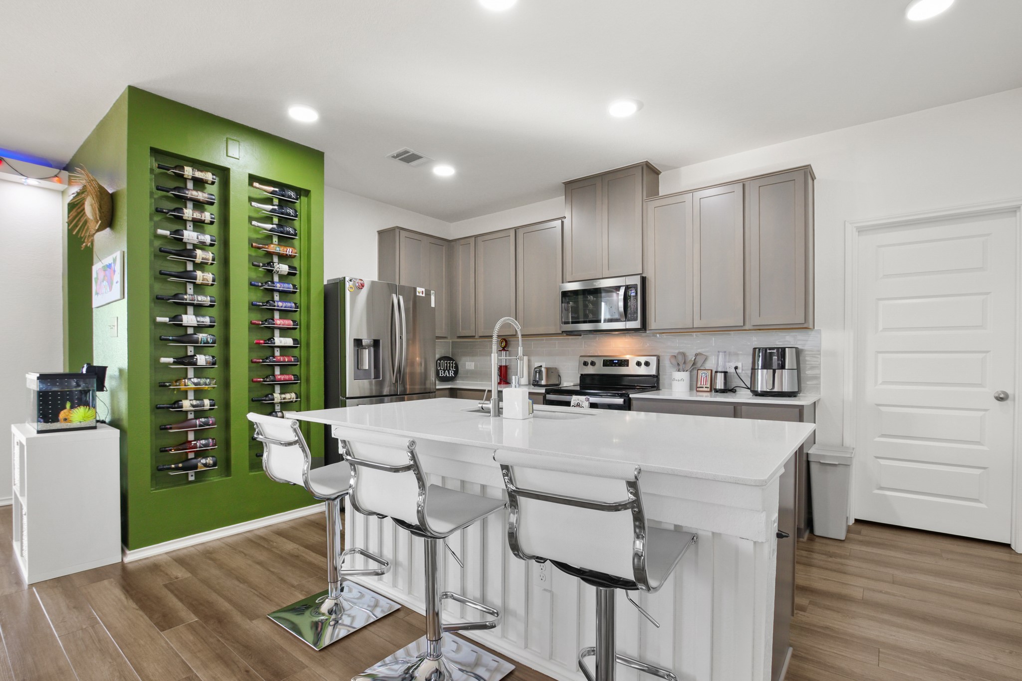 102 Whitney Drive Elgin, TX 78621 - Photo 6 of 24 a kitchen with stainless steel appliances granite countertop a refrigerator a stove top oven a sink dishwasher and white cabinets with wooden floor