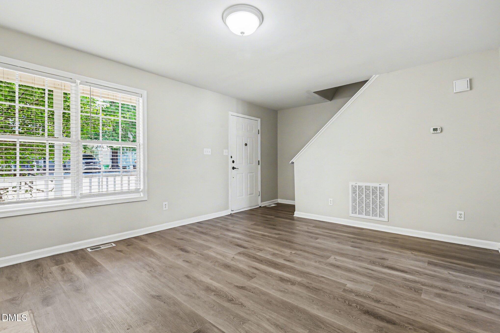 4816 Windbreak Lane Raleigh, NC 27616 - Photo 2 of 17 a view of an empty room with wooden floor and a window