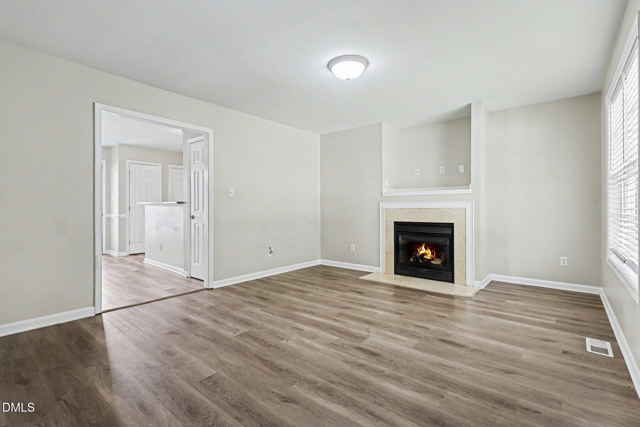4816 Windbreak Lane Raleigh, NC 27616 - Photo 3 of 17 a view of empty room with wooden floor and fireplace