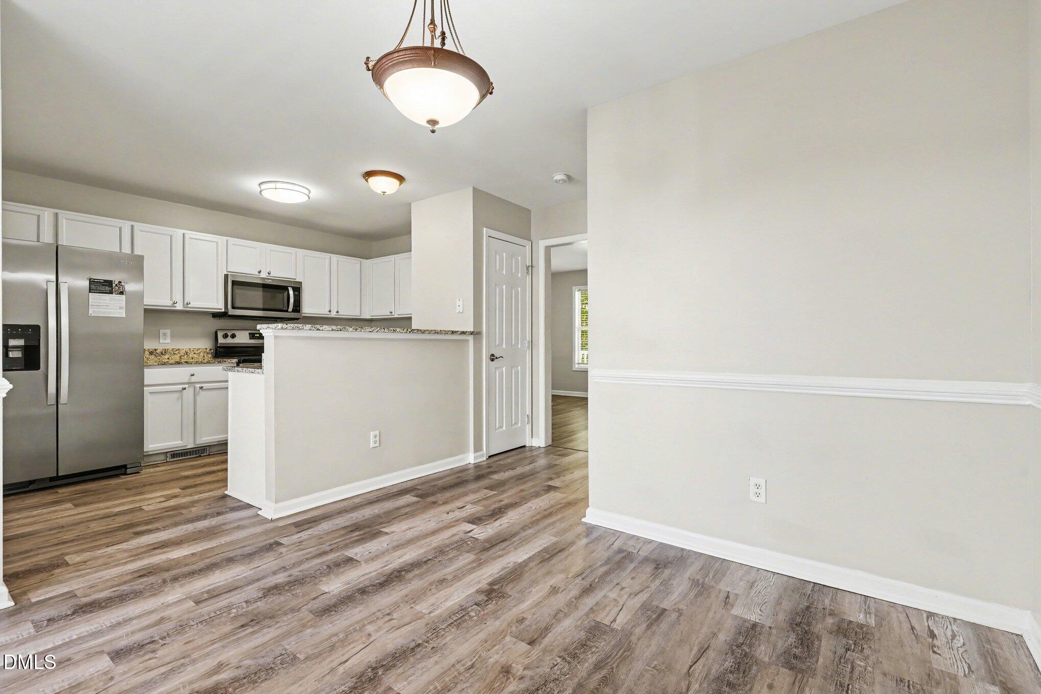 4816 Windbreak Lane Raleigh, NC 27616 - Photo 4 of 17 a view of a kitchen with wooden floor and electronic appliances