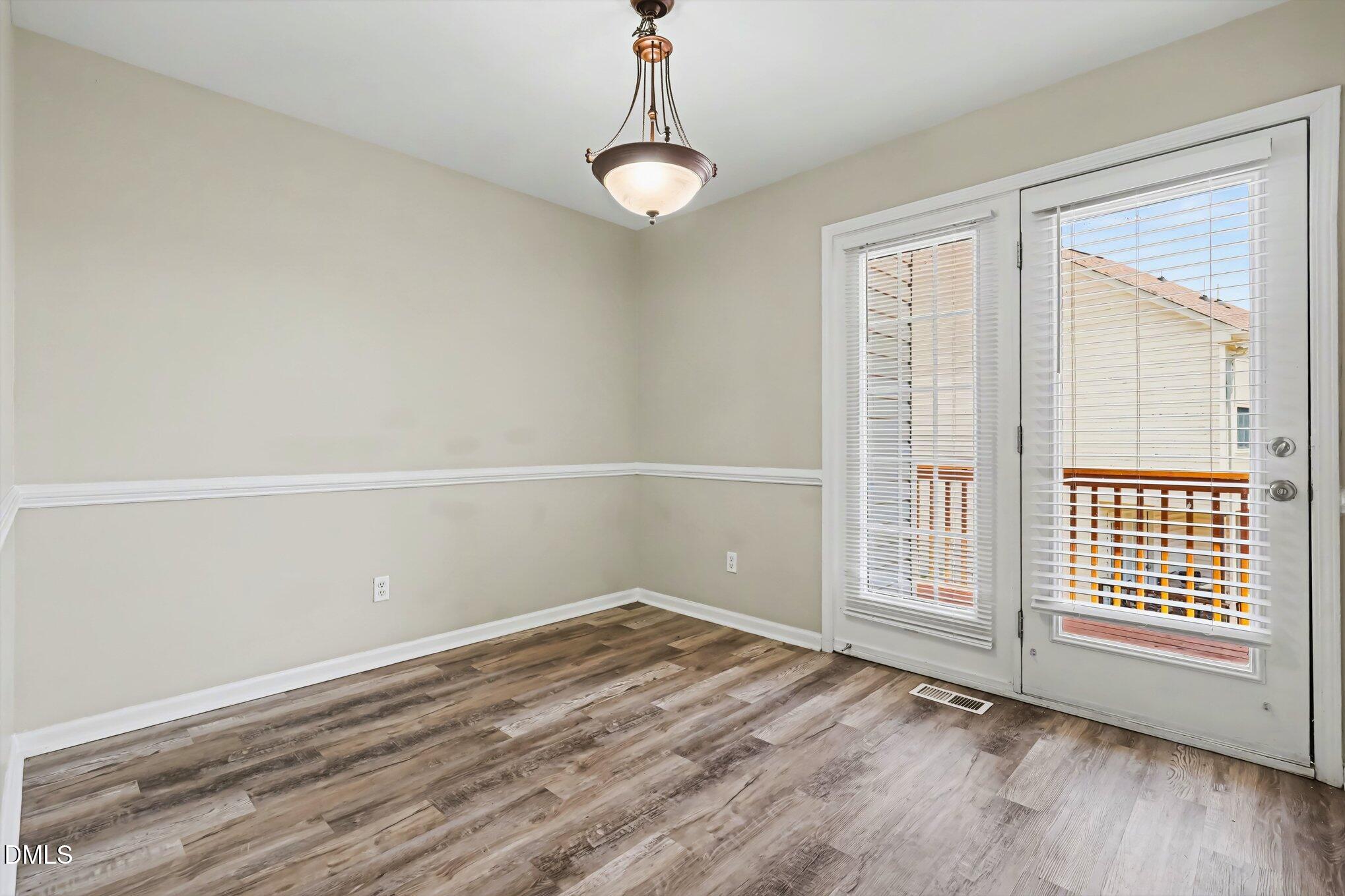 4816 Windbreak Lane Raleigh, NC 27616 - Photo 7 of 17 a view of an empty room with wooden floor and a window