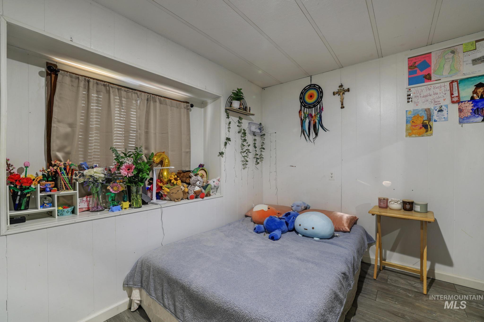 1625 Maple Street, Unit 20 Buhl, ID 83316 - Photo 12 of 17 Bedroom with wood finished floors and wood walls