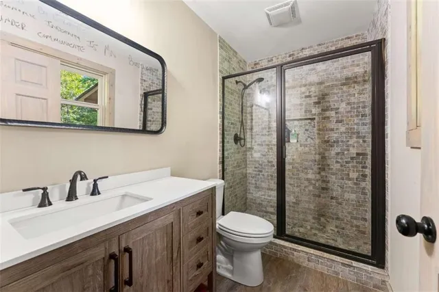 a bathroom with a sink a mirror a toilet and shower