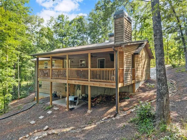 a view of a house with a yard chairs and wooden fence