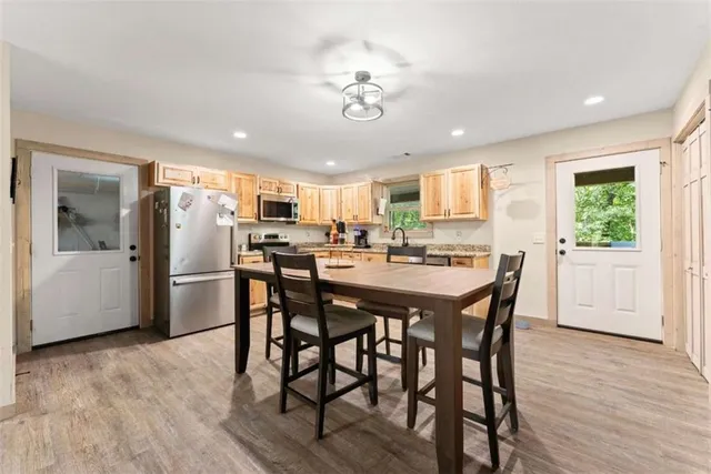 a kitchen with a dining table chairs and refrigerator
