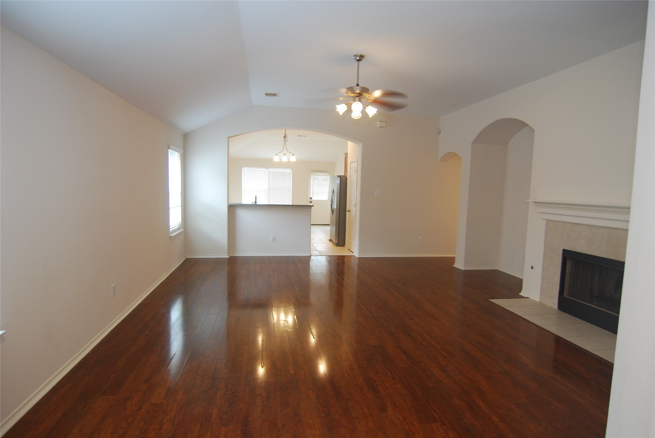 2834 Lockeridge Pines Drive Spring, TX 77386 - Photo 2 of 20 This spacious living area features rich laminate floors, a cozy fireplace, and an open layout leading to the kitchen. Natural light fills the room, enhancing its inviting atmosphere.