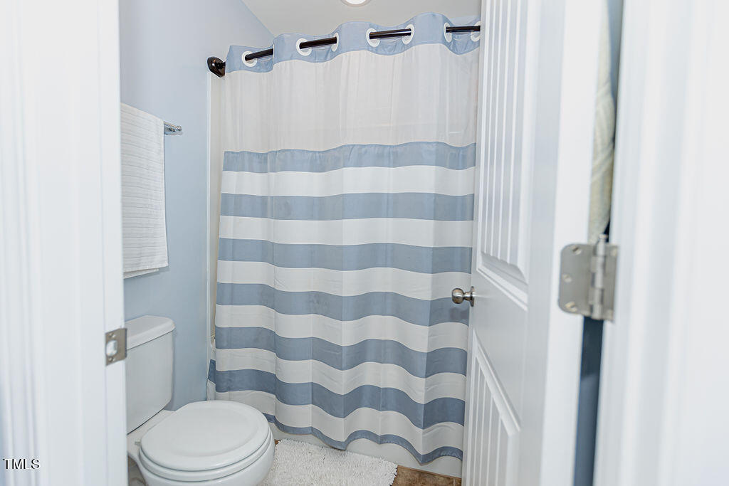 3220 Lacewing Drive Zebulon, NC 27597 - Photo 28 of 69 a white toilet sitting next to a shower curtain
