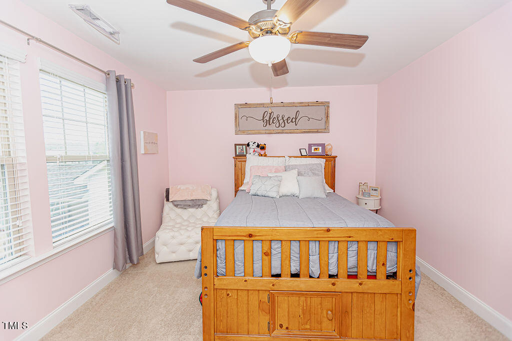3220 Lacewing Drive Zebulon, NC 27597 - Photo 31 of 69 a bedroom with a bed and a chandelier