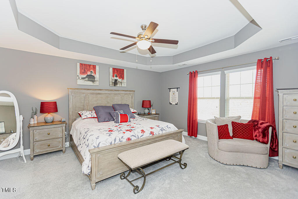 3220 Lacewing Drive Zebulon, NC 27597 - Photo 38 of 69 a bedroom with a bed and a chandelier