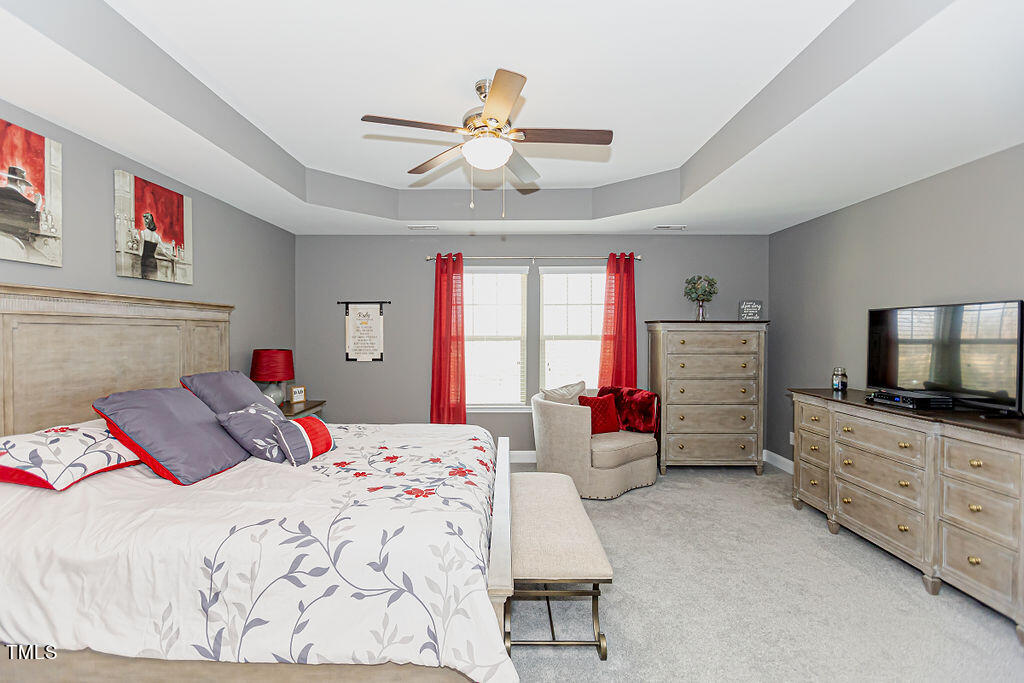 3220 Lacewing Drive Zebulon, NC 27597 - Photo 39 of 69 a bedroom with a bed and a flat screen tv