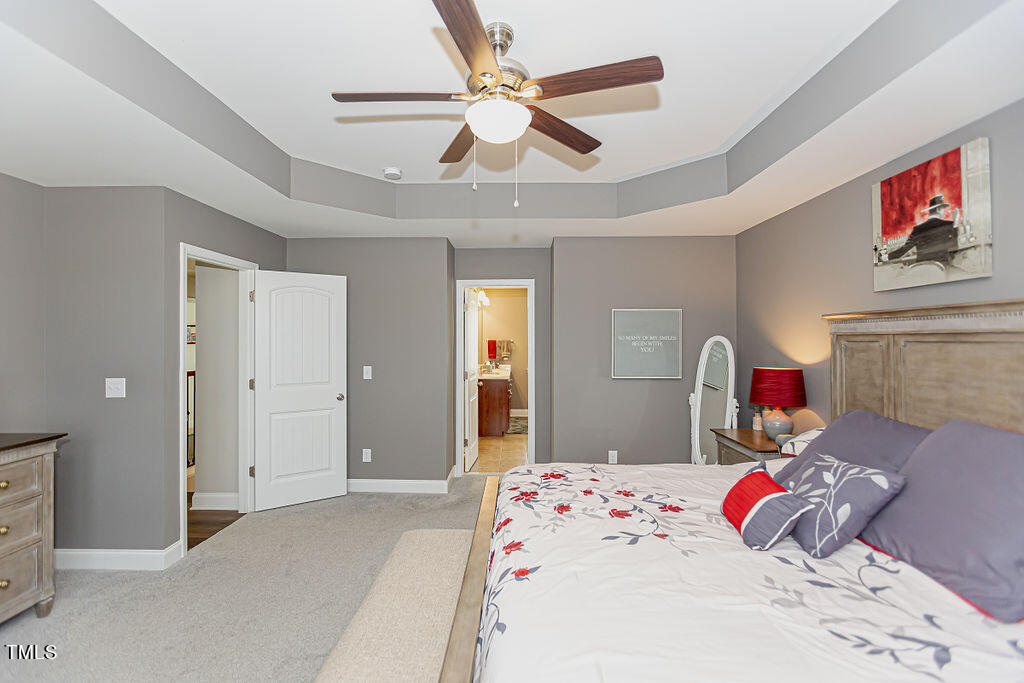 3220 Lacewing Drive Zebulon, NC 27597 - Photo 41 of 69 a bedroom that has a bed and a chandelier