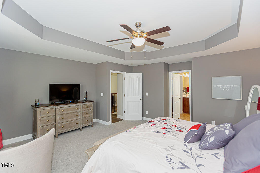 3220 Lacewing Drive Zebulon, NC 27597 - Photo 42 of 69 a bedroom with a bed and a flat screen tv