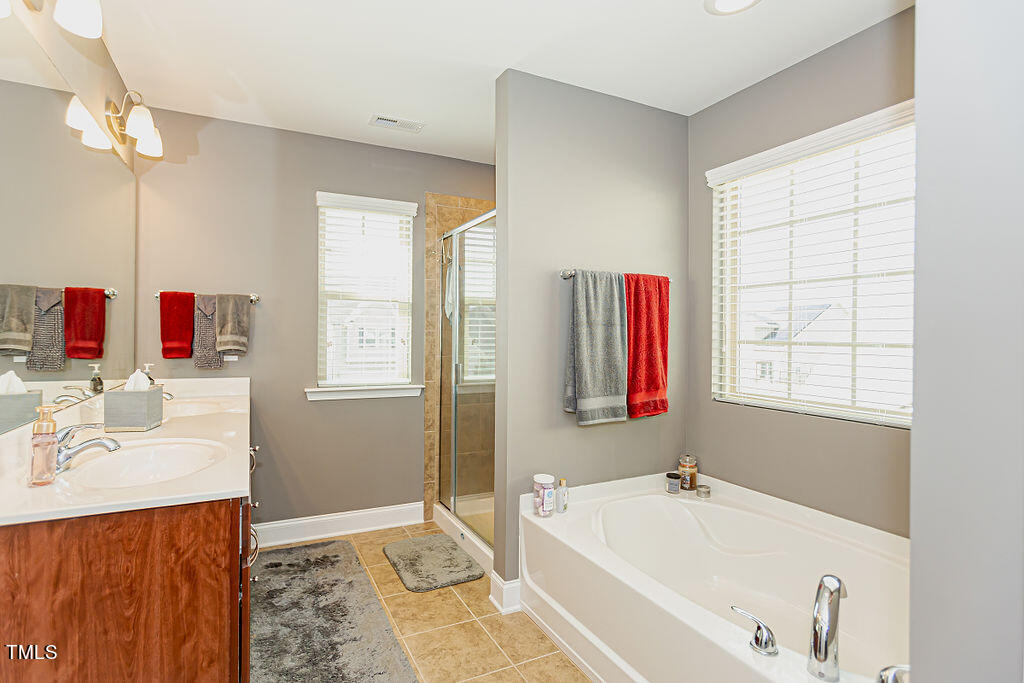 3220 Lacewing Drive Zebulon, NC 27597 - Photo 44 of 69 a bathroom with a tub sink and mirror