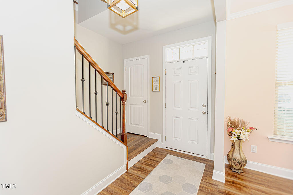 3220 Lacewing Drive Zebulon, NC 27597 - Photo 5 of 69 a view of a hallway with wooden floor and staircase