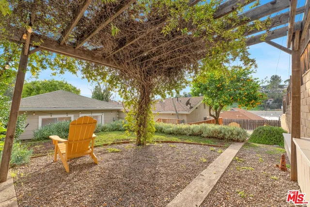 a view of a house with backyard and a tree