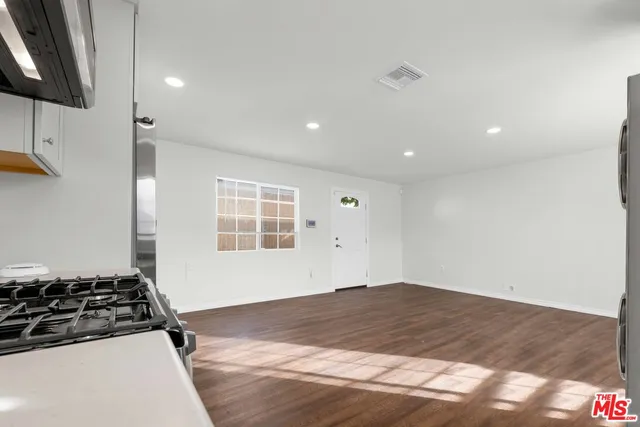 a view of empty room with wooden floor and stove