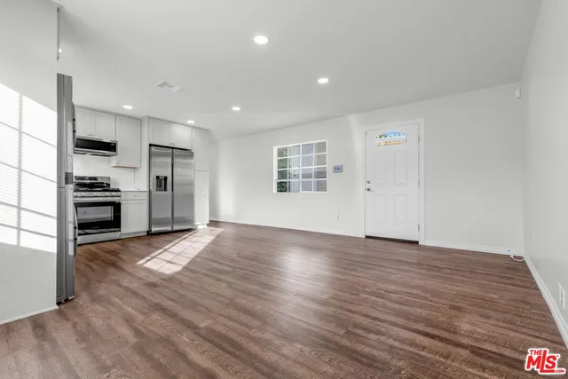 a view of kitchen with refrigerator stove and wooden floor