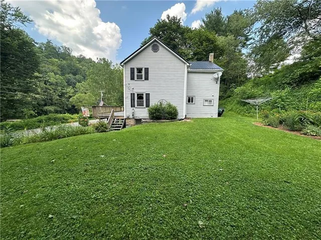 a view of a house with a yard and sitting area