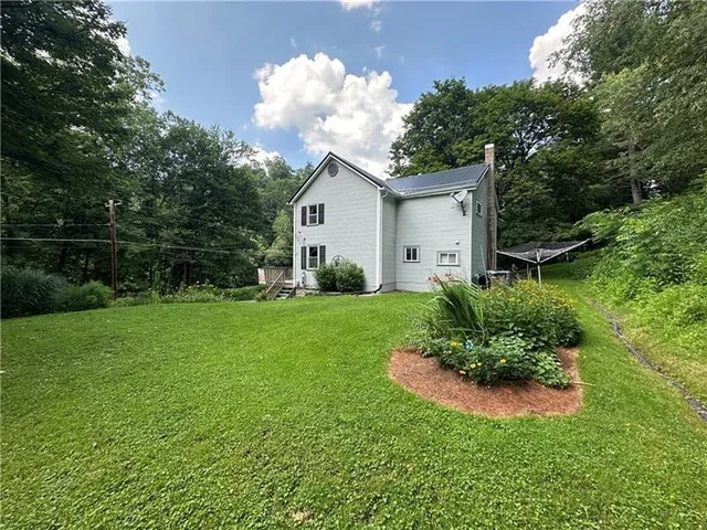 a view of a house with a backyard and a garden
