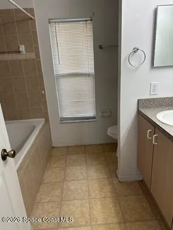 a bath tub sitting next to a white sink and vanity