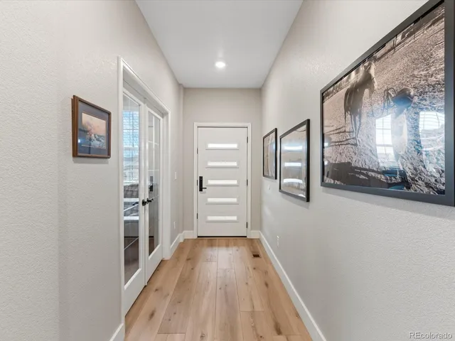 a view of hallway with a large window and wooden floor