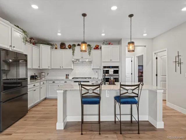 a kitchen with stainless steel appliances kitchen island granite countertop a stove a sink and a refrigerator