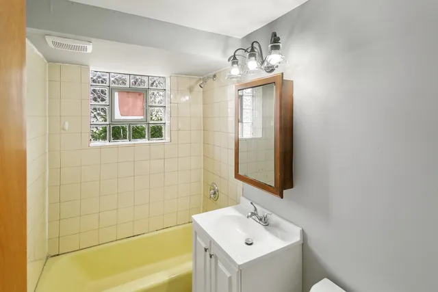 a bathroom with a sink mirror and a bathtub