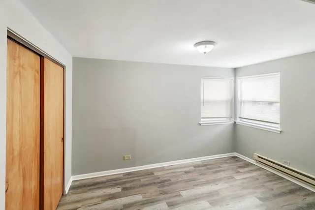 an empty room with windows and closet